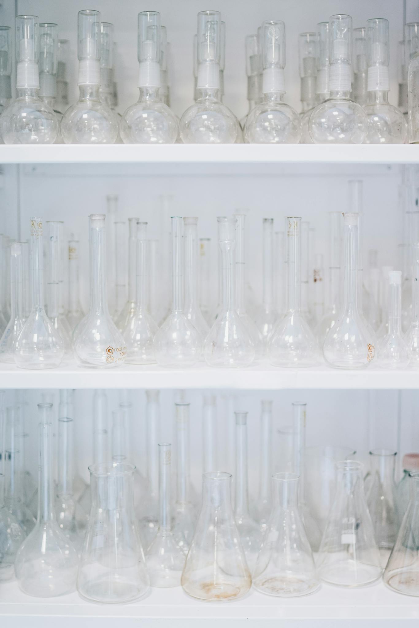 Assorted flasks in a laboratory setting showcasing transparent glassware.