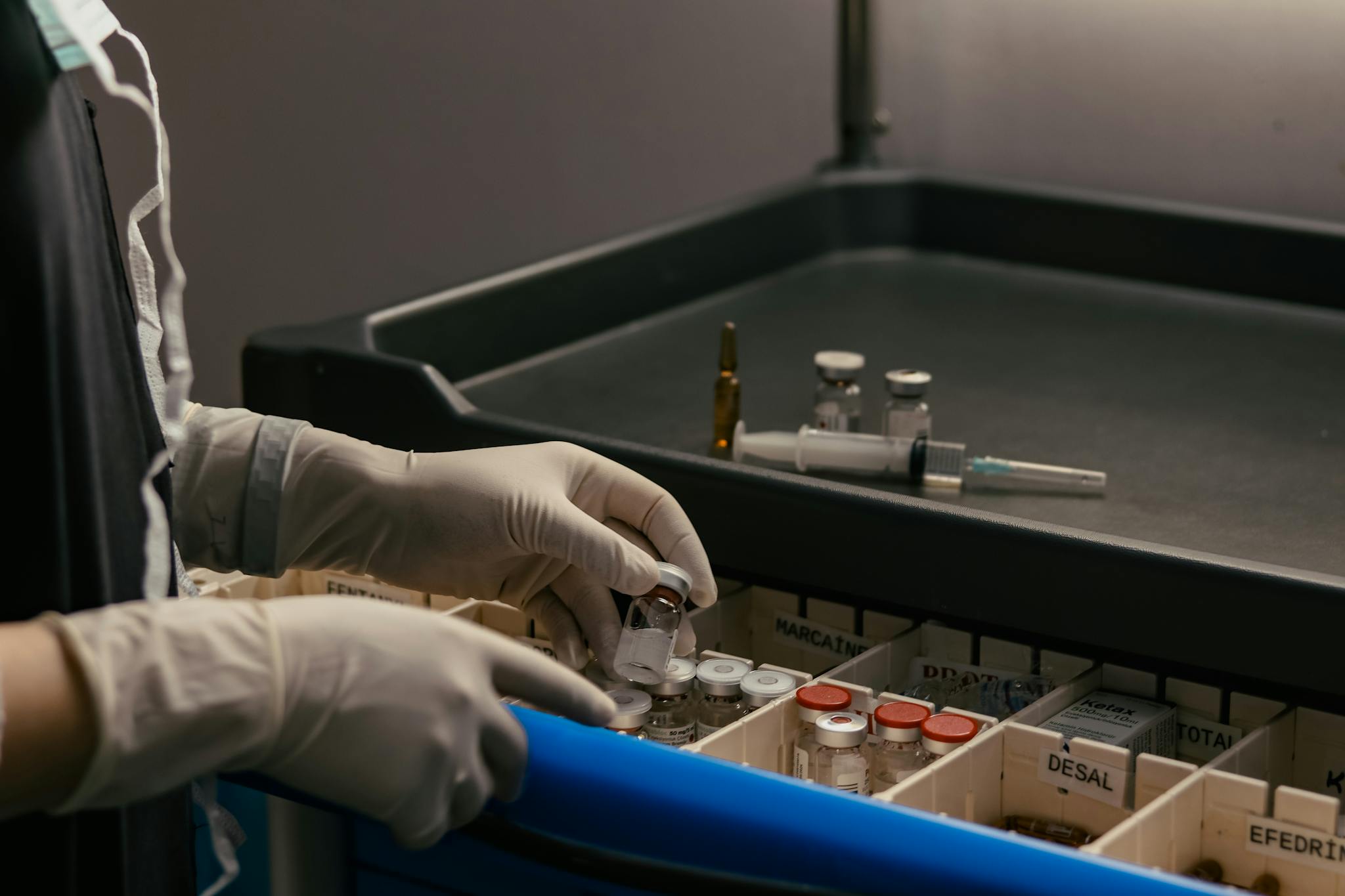 Gloved hands organizing vials in a medical setting, emphasizing precision and hygiene.